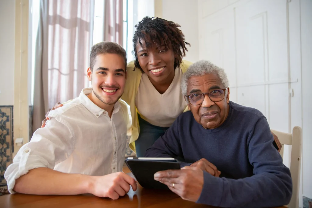 Resident and caregivers looking at a tablet together