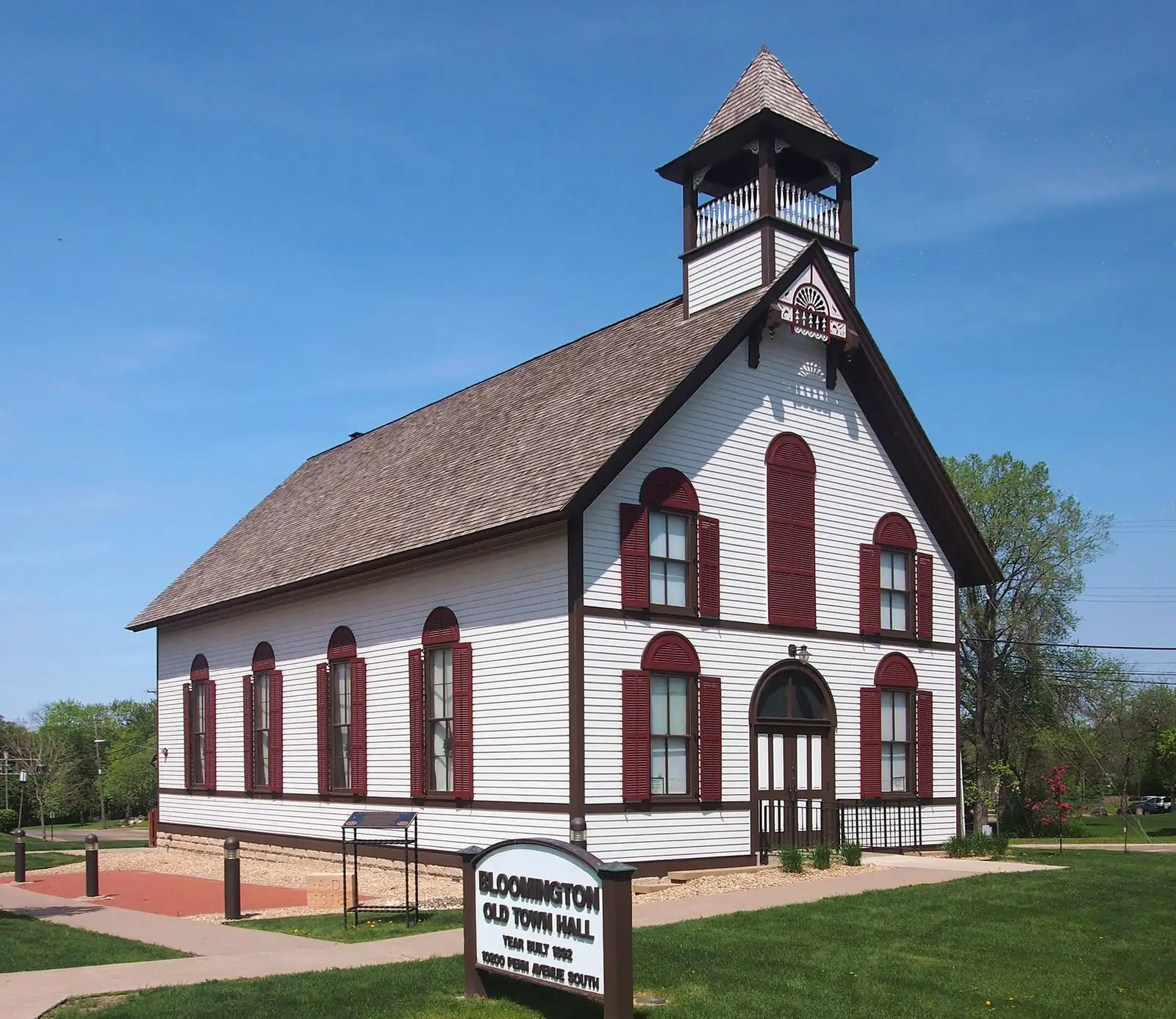 Bloomington’s white Old Town Hall with red trim and a bell tower on Penn Avenue South