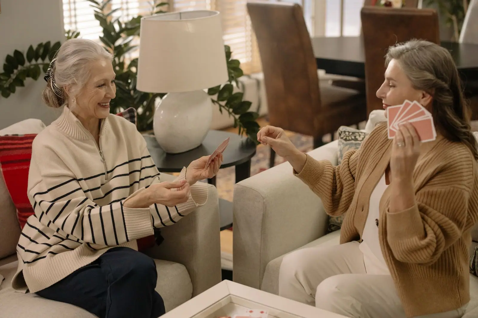 Two older women playing cards in a living room (representative photo)