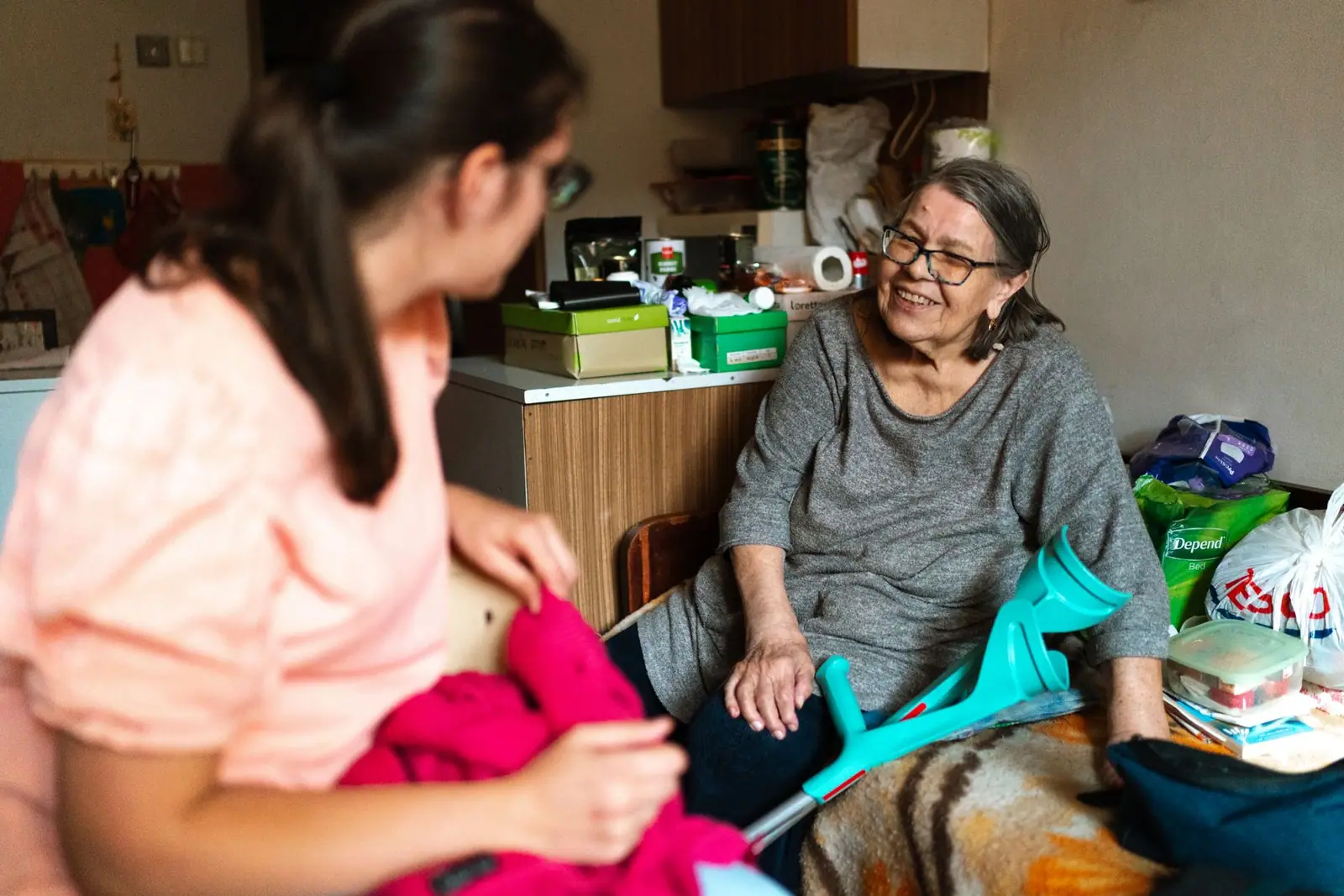 Caregiver laughing with an older woman at home (representative photo)