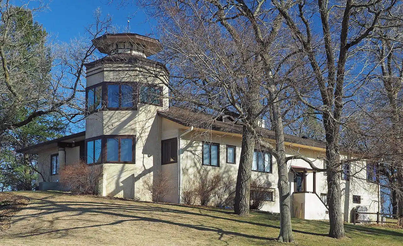The historic Emil J. Oberhoffer House with its tower among bare trees in Lakeville, Minnesota
